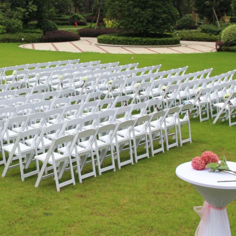White Plastic Folding Chairs Arranged at Outdoor Wedding